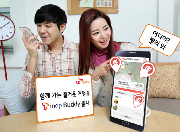 SK플래닛, 그룹 위치공유 서비스 ‘T맵 버디(Buddy)’ 출시 관련 홍보 사진입니다. 왼쪽 모델은 핸드폰을 들고 있고 앞에는 함께 가는 즐거운 여행길 T맵 버디 출시라는 배너가 있습니다. 오른쪽에는 휴대폰 앱 구동화면을 가리키고 있는 모델이 있습니다.